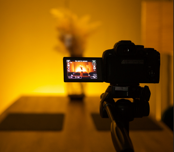 A professional mirrorless camera mounted on a tripod in a high-quality creator studio with cinematic lighting.
