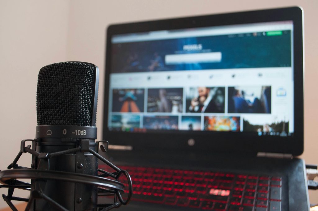 Best Microphone for YouTube Creators: Your 2026 Definitive Guide Professional studio microphone on a shock mount in front of a creator laptop with a glowing red keyboard.
