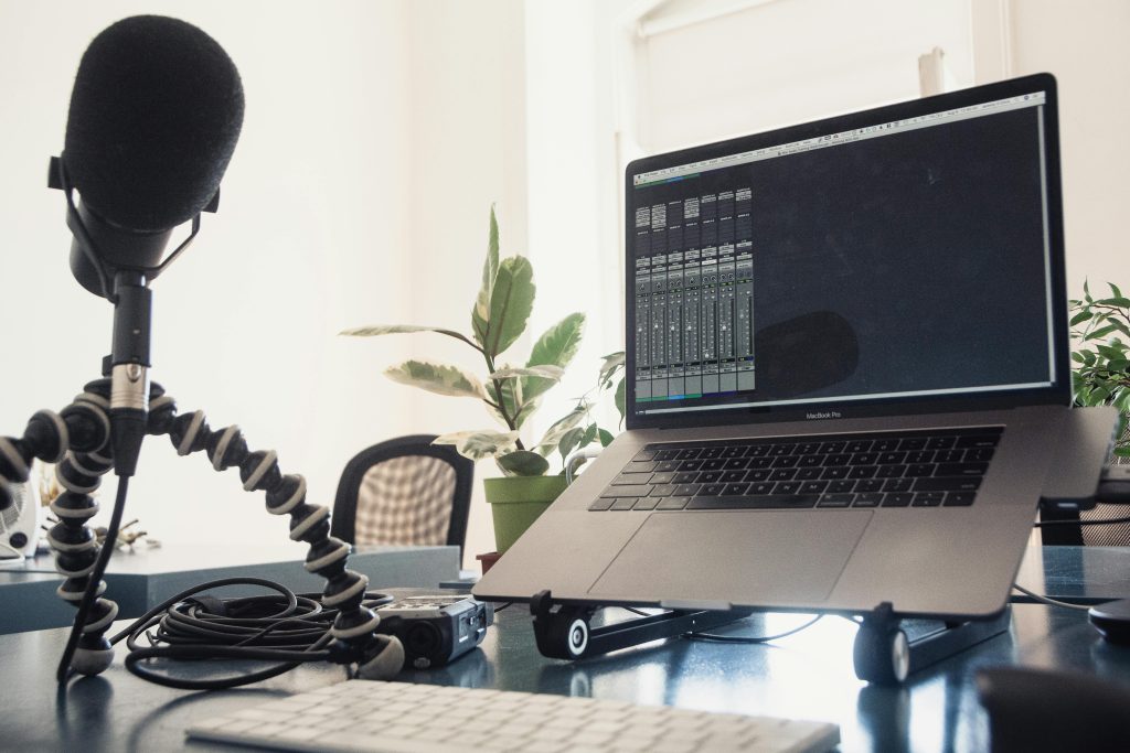 A clean and organized home podcast studio setup for content creators, featuring a desk and professional recording gear.