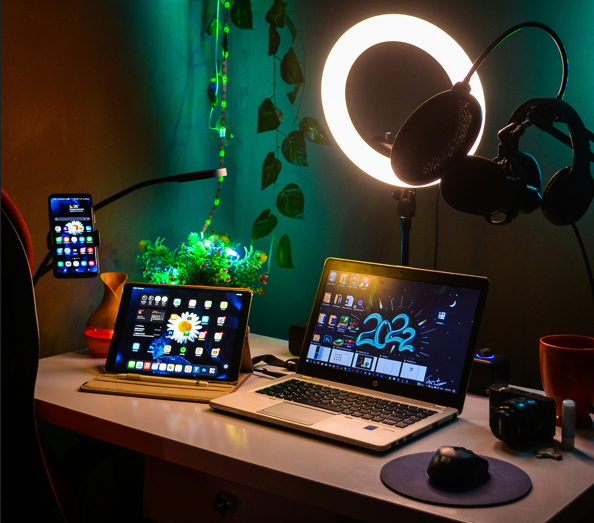 A complete creator workstation with a laptop, tablet, ring light, and professional RGB ambient lighting for streaming